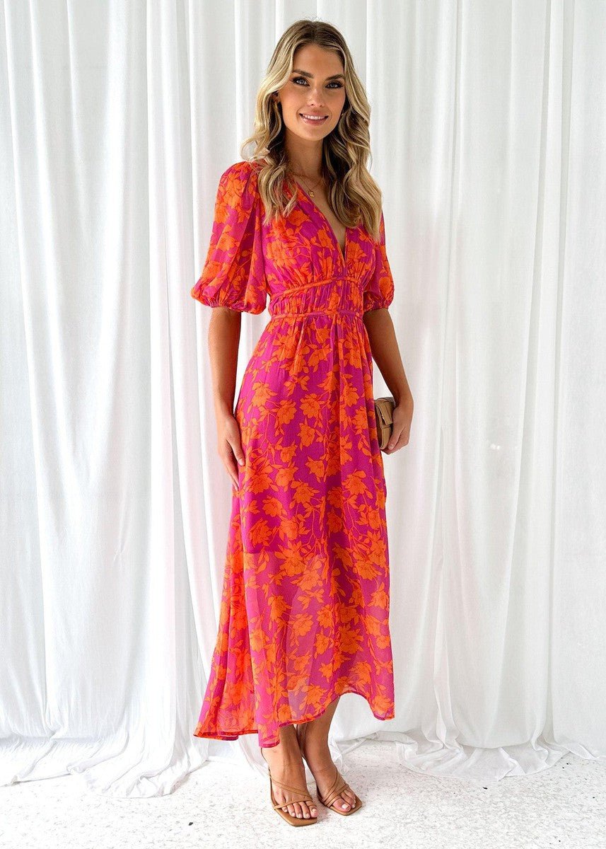 Elegant women's flowing pink & orange floral maxi dress, V-neck, short puff sleeves, ideal for warm weather.