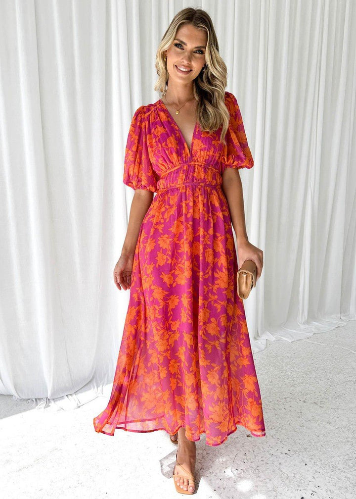 Stylish women's pink-orange floral maxi dress with V-neck & puff sleeves, a perfect elegant summer vacation outfit.