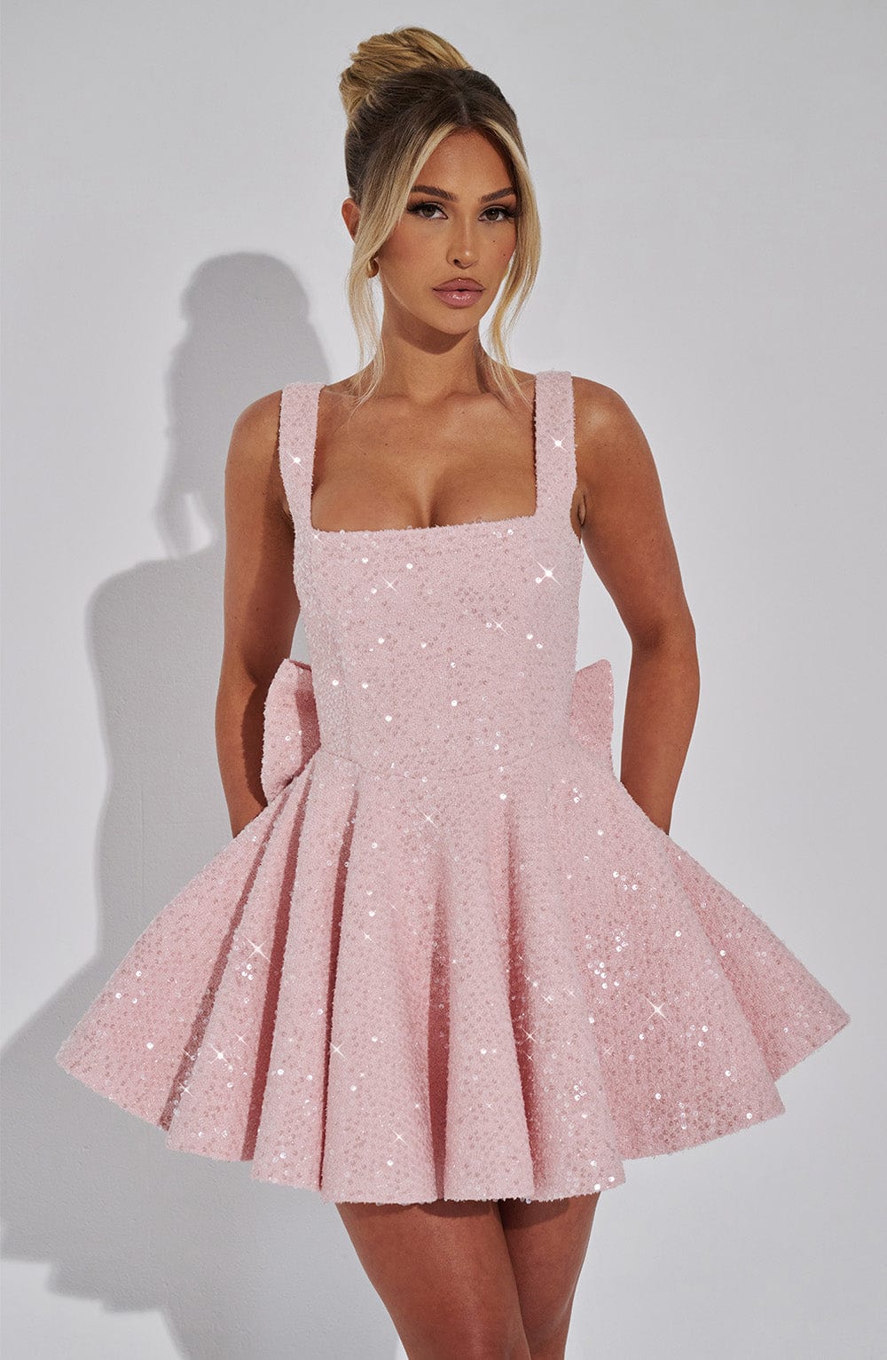 Elegant short pink sequin skater dress with a bow, a dazzling choice for women's homecoming or evening wear.