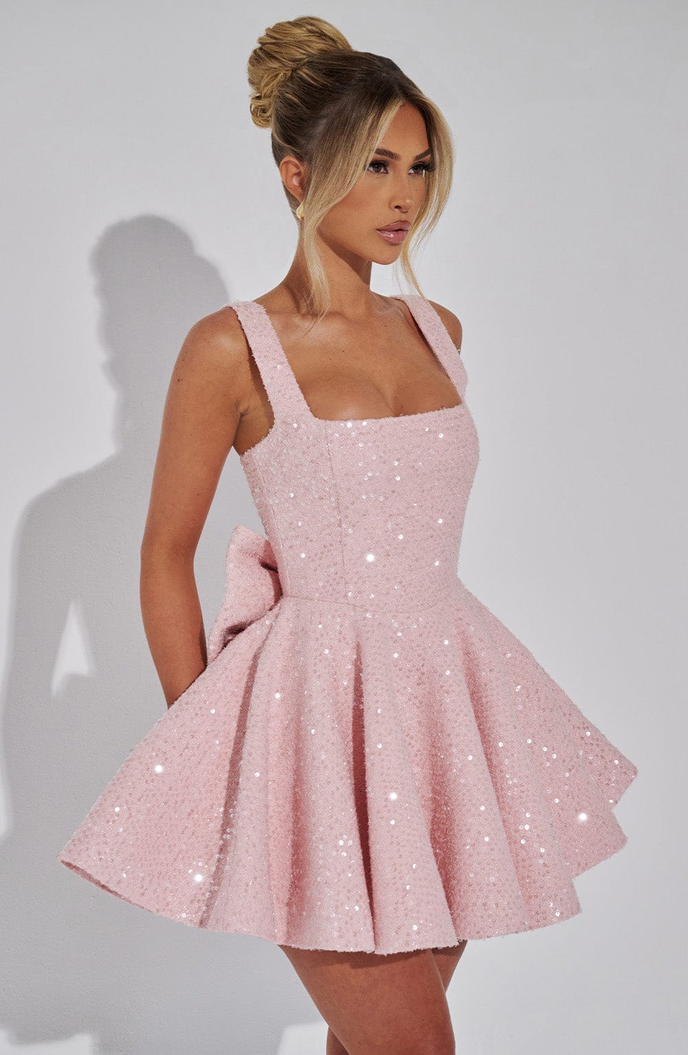 Women's pink sequin skater dress with a bow, short style for homecoming, parties, or special occasions.