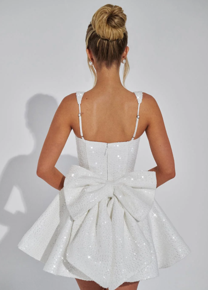 Women's pink sequin homecoming dress, short skater style with a delicate bow, perfect for dancing.