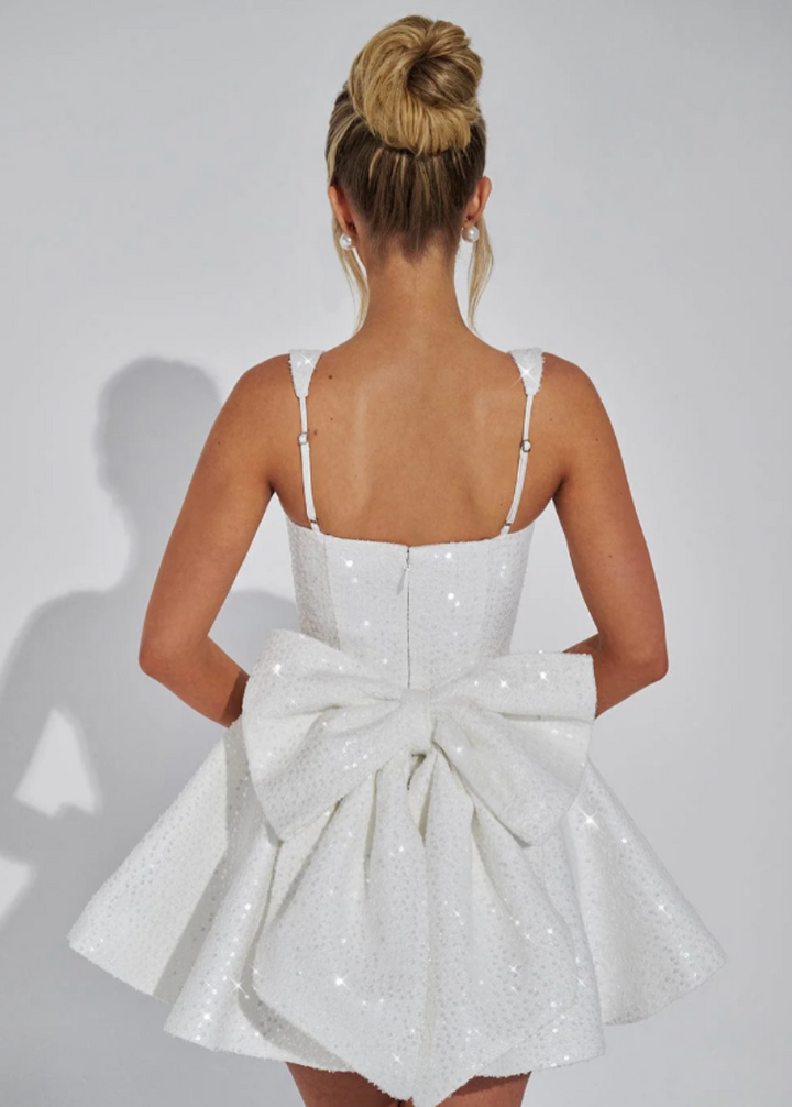 Women's pink sequin homecoming dress, short skater style with a delicate bow, perfect for dancing.