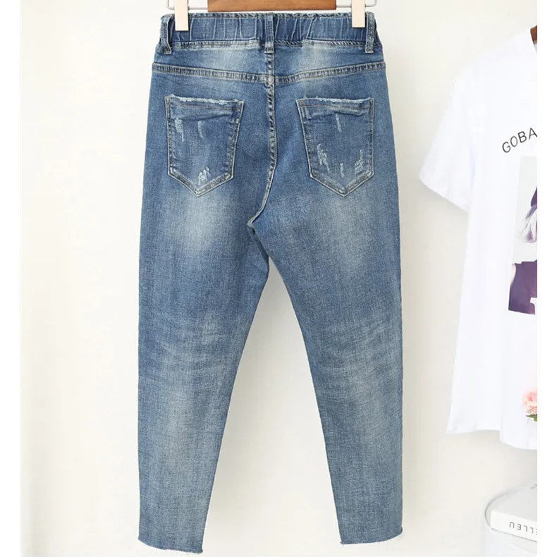 Side view of a model wearing plus size high-waisted baggy jeans. Relaxed fit, stretch denim for casual wear.