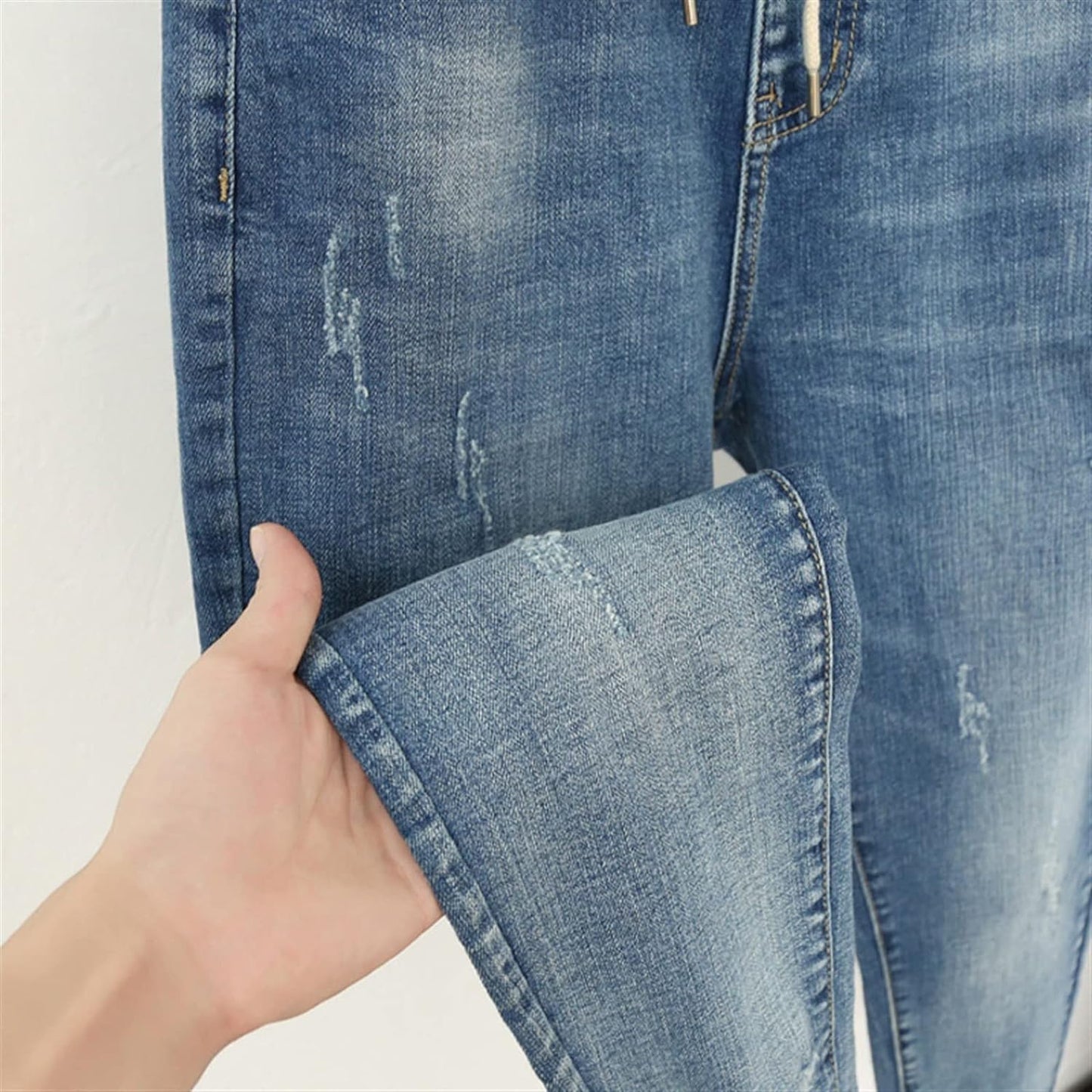 Close-up of the stretch denim fabric on women's plus size high-waisted baggy jeans, showcasing quality.