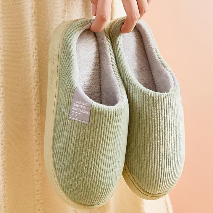 Cozy women's plush house slippers with non-slip soles, perfect for home comfort.