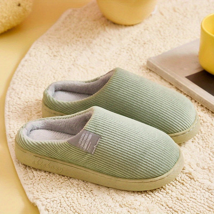 Soft plush women's slip-on slippers with cushioned footbed & durable non-slip sole for home.