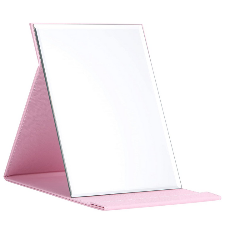 Pink compact make-up mirror with stand, a portable beauty accessory and cosmetic tool for women.