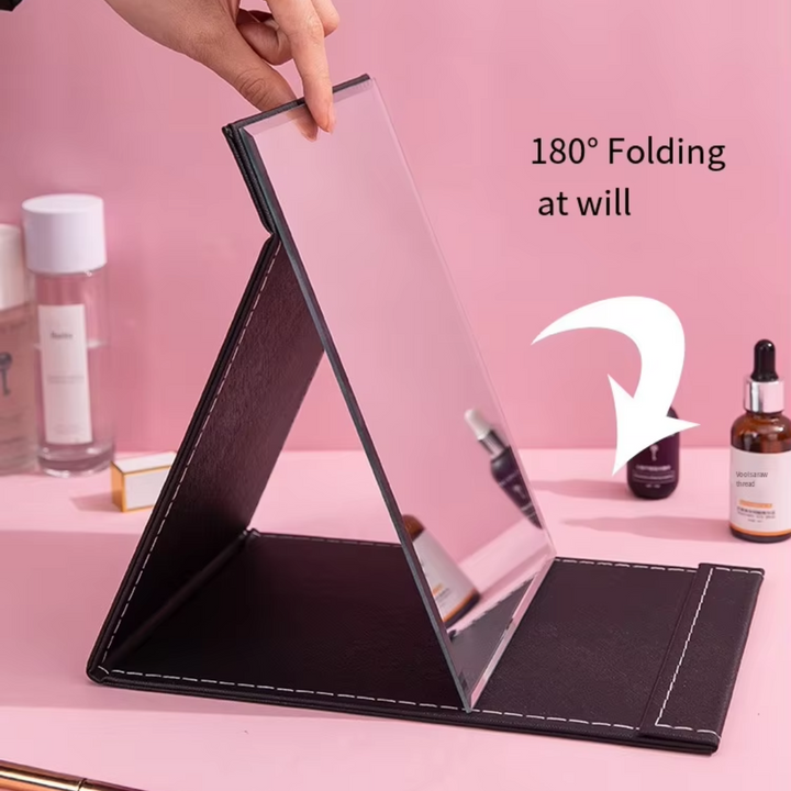 Sleek black travel make-up mirror with stand, a portable cosmetic tool and women's beauty essential.