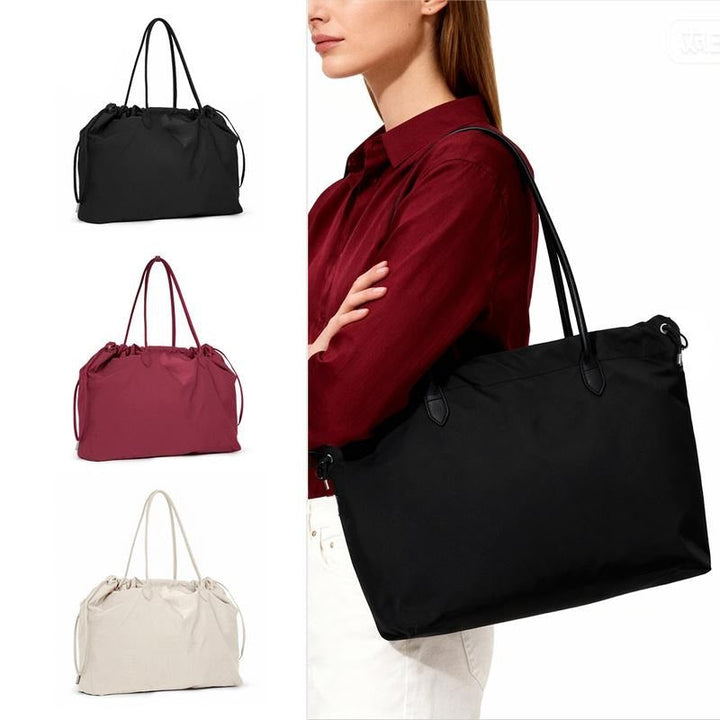 Woman with a black premium leather work tote bag, a chic & spacious minimalist accessory.