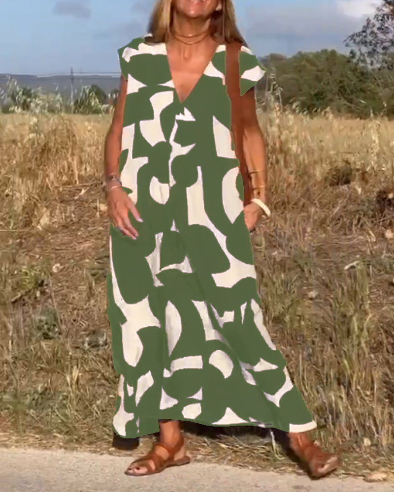 Side profile of a woman wearing a relaxed fit abstract V-neck dress with cap sleeves.