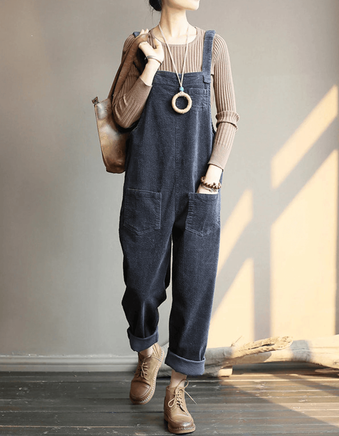 Women's relaxed fit dungaree jumpsuit featuring wide legs, adjustable straps, and patch pockets. Versatile casual wear.