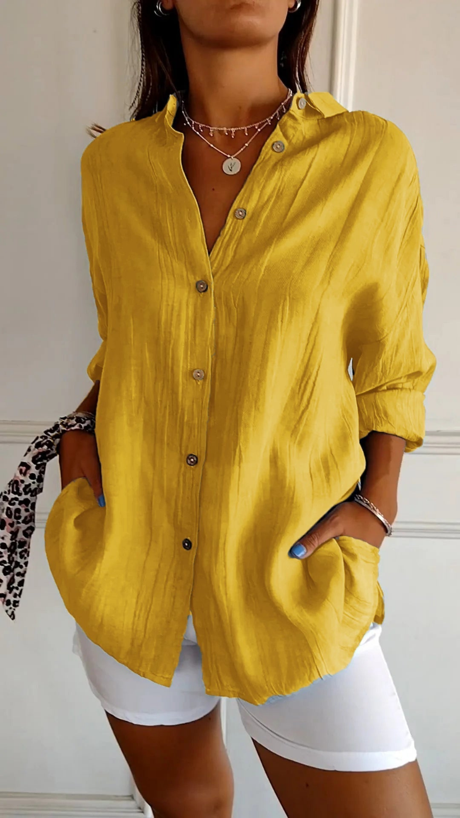 Woman in a relaxed oversized button-up shirt with long sleeves, styled casually for versatile wear.