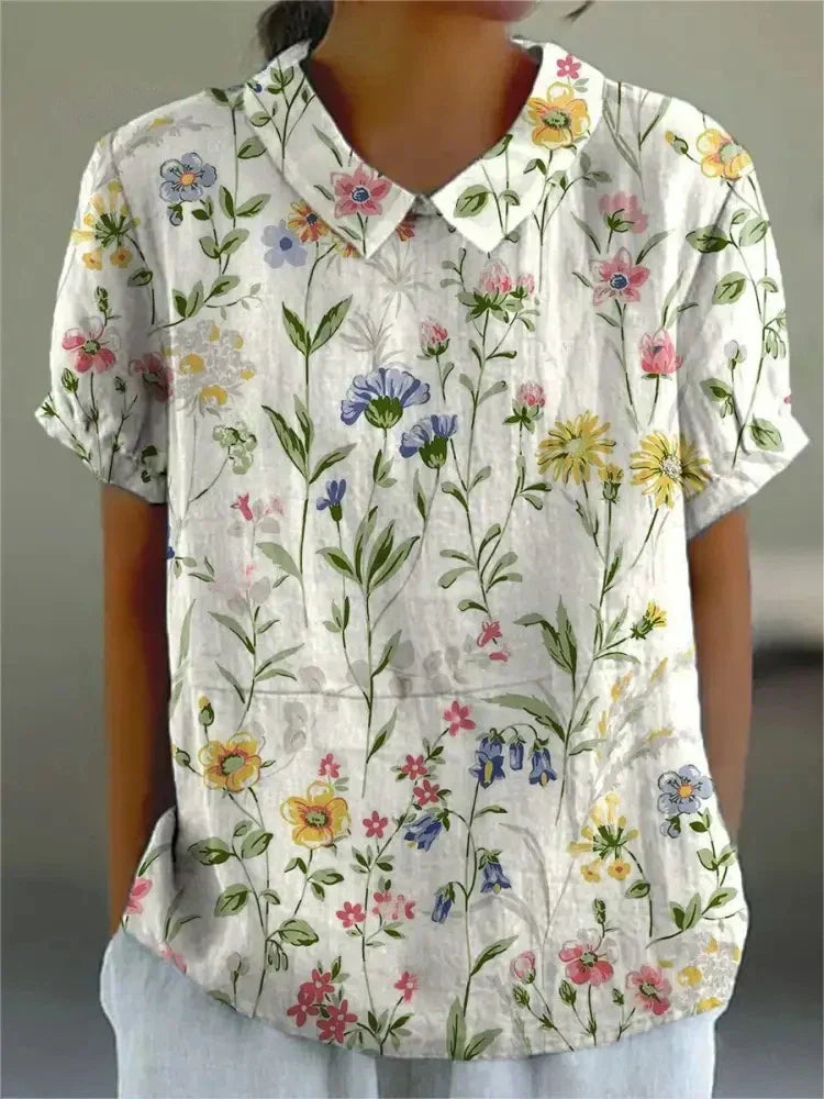 Vintage style women's collared blouse with delicate floral embroidery, short sleeves.