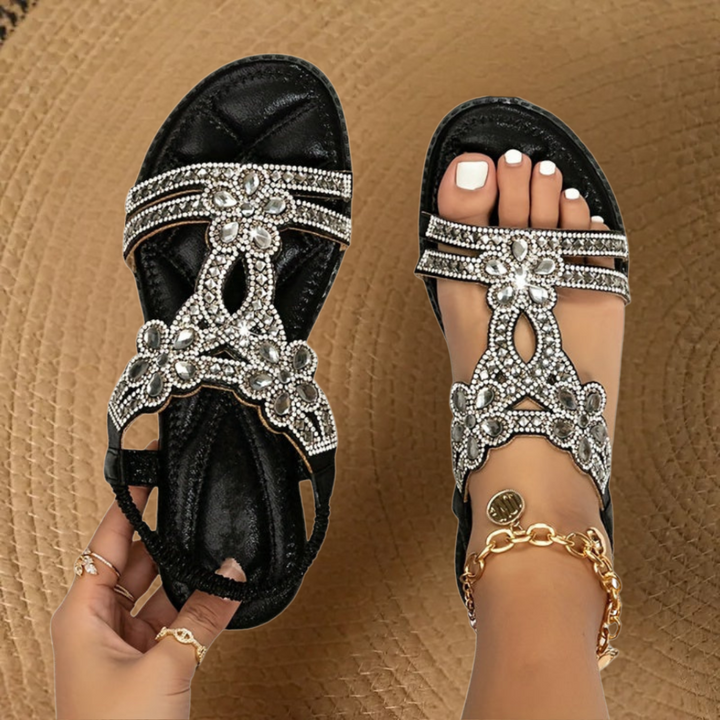 Embellished women's flat sandals showcasing beautiful rhinestones, a chic and comfortable summer footwear option.