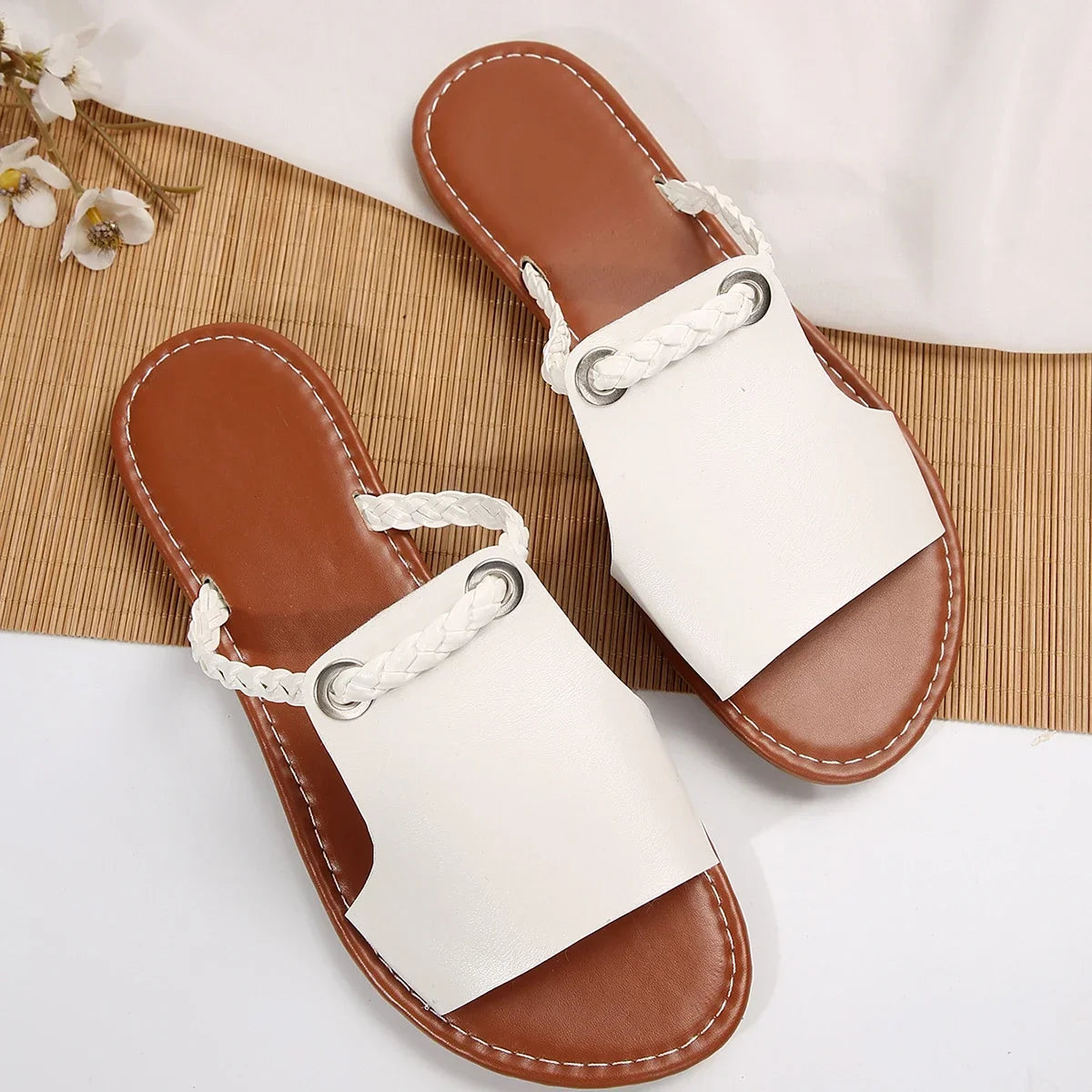 Black braided slip-on flat sandals for women, versatile summer casual footwear.