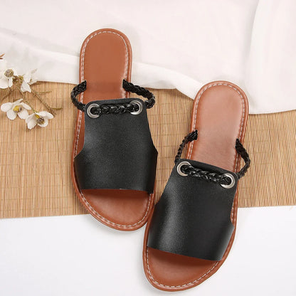 Casual women's footwear: classic black braided slip-on flat sandals for summer.