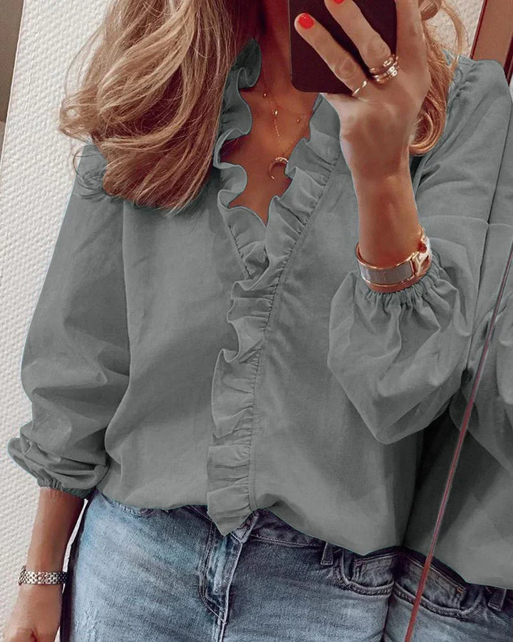 Detailed view of a women's ruffle V-neck blouse, showcasing the elegant button front and soft, comfortable fabric.