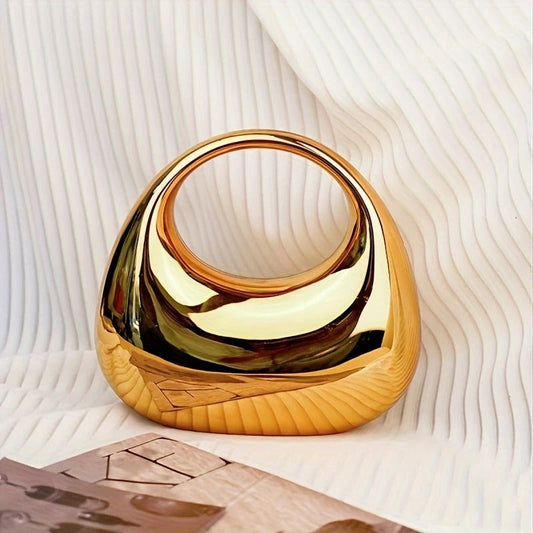 Women's sculptural clutch bag with mirror finish, perfect for elegant evening events.