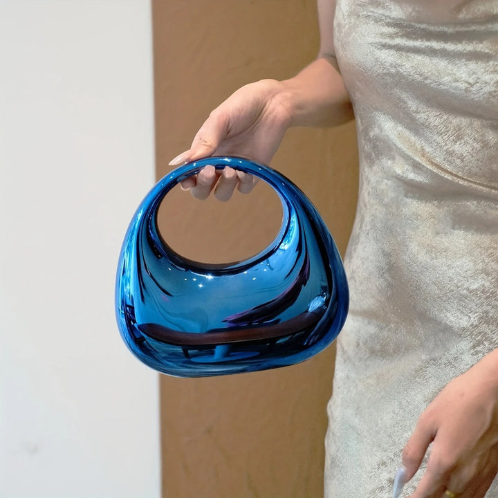 Women's fashion clutch, mirror finish, bold sculptural design for a striking look.
