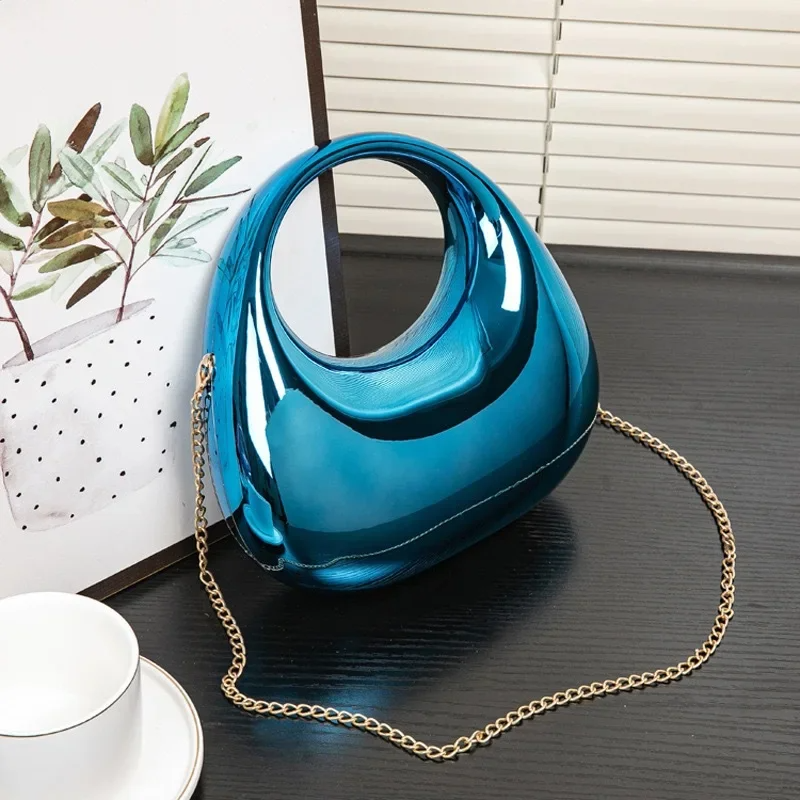 Reflective women's evening bag, a sculptural acrylic clutch with a mirror-like surface.