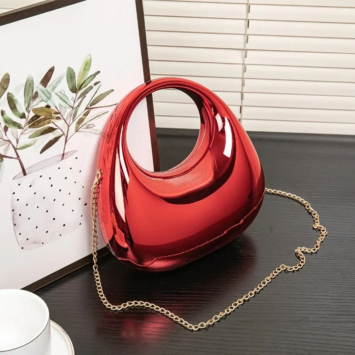 Women's party clutch, mirror finish, unique sculptural design, perfect for a night out.