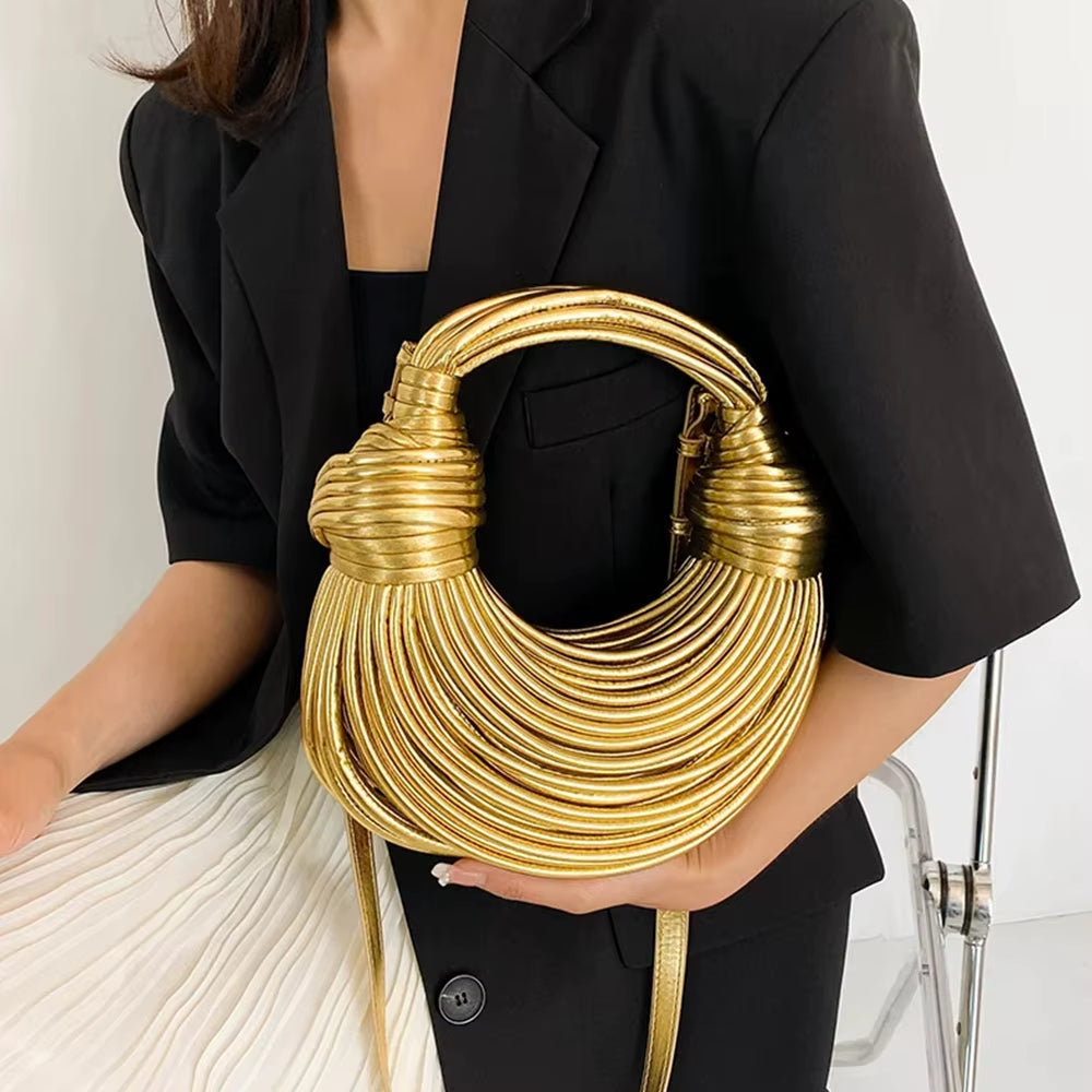 Sculptural vegan leather handbag with metallic accents for women. Luxury fashion accessory, statement bag.