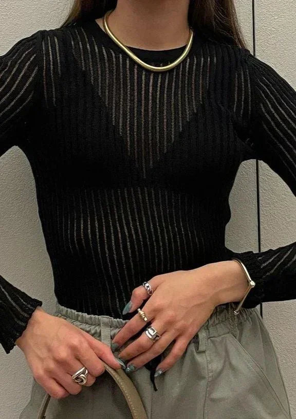 Woman wearing a stylish sheer ribbed long sleeve top, comfortable and elegant for modern fashion trends.