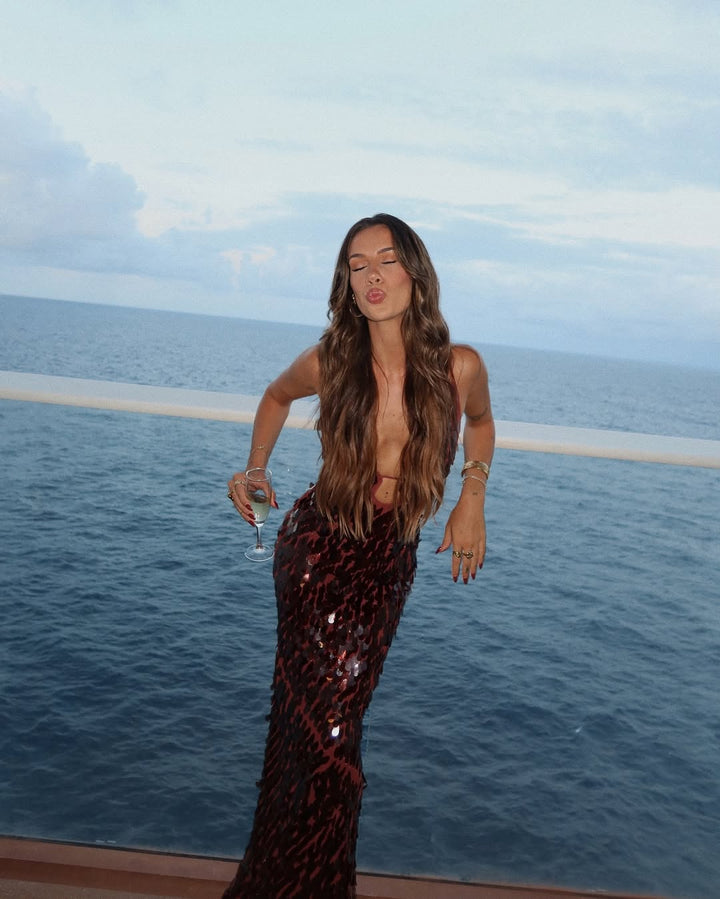 Full-length view of a women's stunning red sequin maxi dress with a bold plunge neck, great for formal wear.