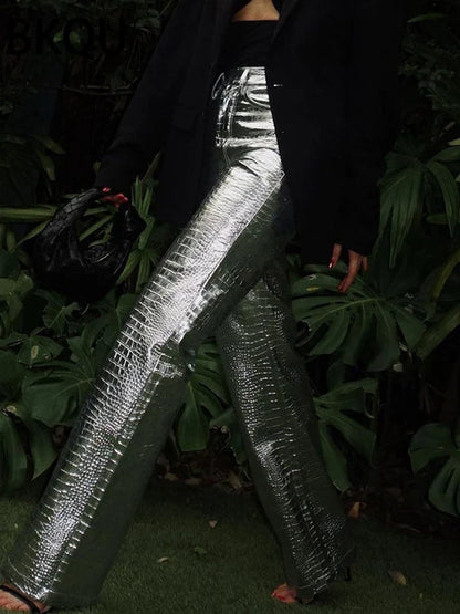 Shimmering silver women's sleek designer style pants. Modern trousers for elegant evening or party wear.