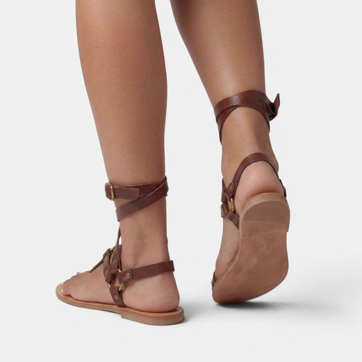 Chic snake print flat sandals for women, with comfortable crossover straps and secure buckle detail.