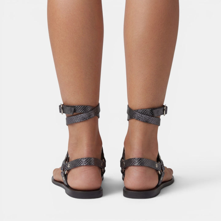 Women's buckled snake print flat sandals with crossover straps, perfect for stylish and comfortable summer wear.