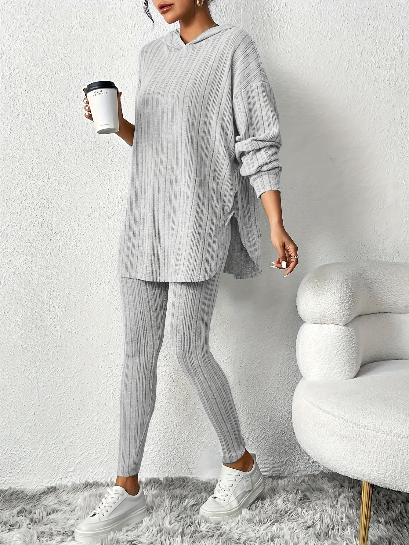Woman relaxing on a couch, wearing a soft ribbed knit two-piece lounge set with hoodie & leggings.