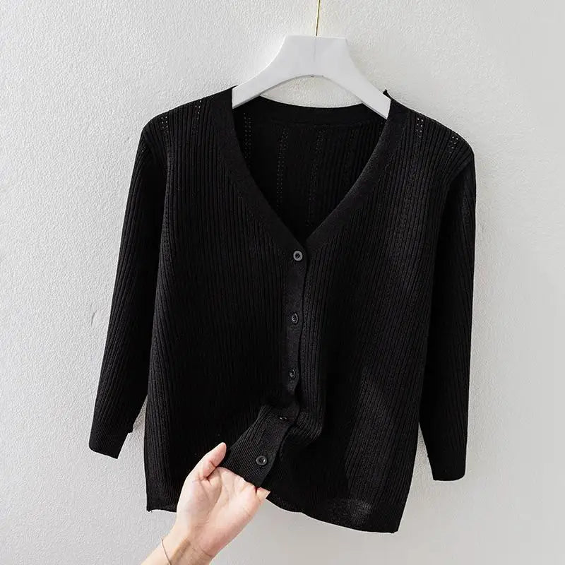 Detail shot of the soft ribbed knit fabric & V-neck collar of a women's long sleeve button-front cardigan.