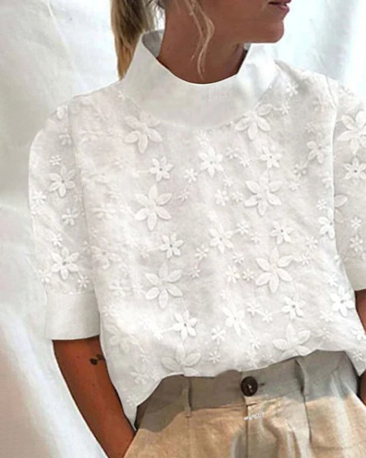 Elegant women's white blouse featuring a unique stand collar & delicate floral embroidery. A sophisticated dressy top.