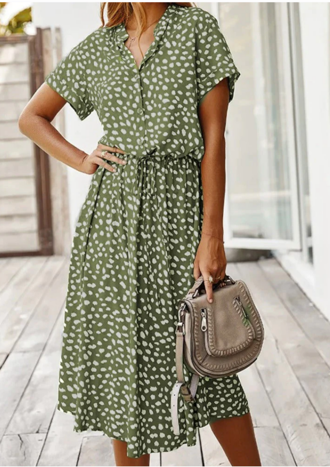 Flowy women's midi dress featuring a stylish spotted print, button-down front & flutter sleeves.