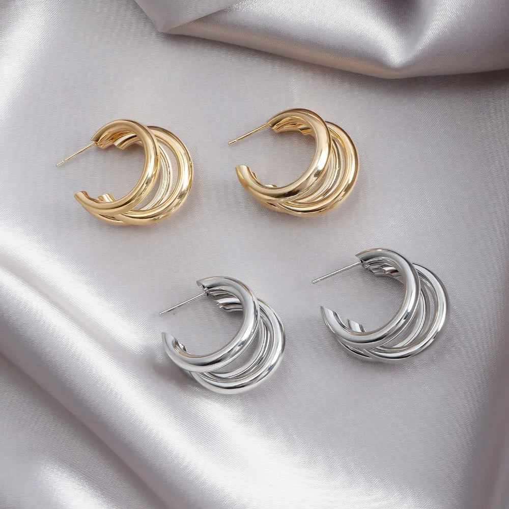 Elegant stacked hoop earrings for women, featuring a mix of gold and silver tones, layered design.