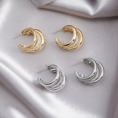Elegant stacked hoop earrings for women, featuring a mix of gold and silver tones, layered design.