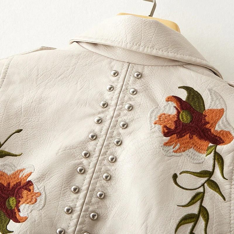 Women's fashion-forward jacket with ornate floral embroidery and cool studs, creating a unique and edgy statement.