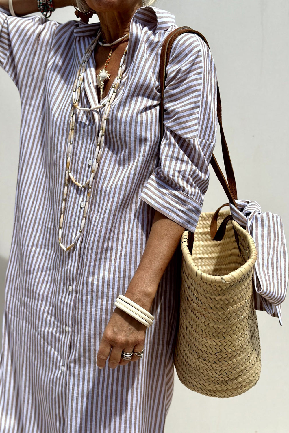 Full length view of a women's striped oversized midi dress, featuring a flattering relaxed fit and collar.