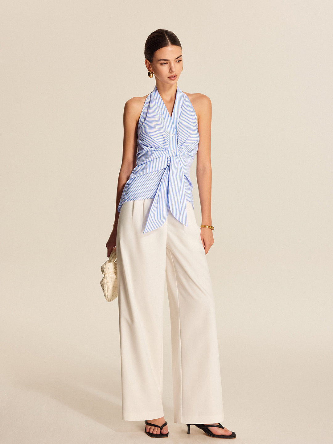 Professional women's sleeveless striped halter blouse, elegant tie front top for work or office.