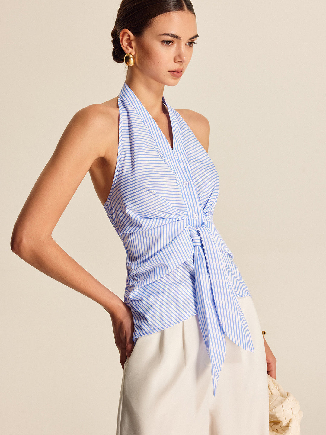 Stylish women's striped halter neck blouse featuring a chic tie-front and sleeveless cut for summer.