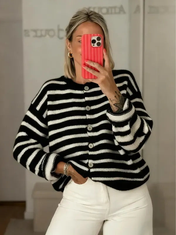 Close-up of women's striped knit cardigan. Soft texture & button-front detail. Versatile fall/winter outerwear.