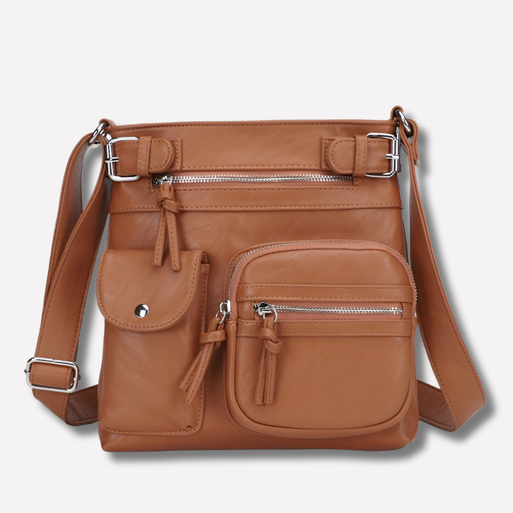 Grey women's crossbody bag, organized with multiple pockets & adjustable strap for versatile travel.