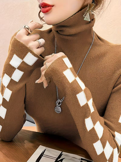 Close-up of stylish check pattern sleeves on a women's high-neck winter sweater, showcasing detail.