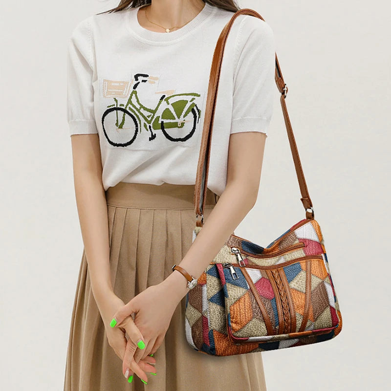 Angled shot of women's multi-color patchwork shoulder bag, sleek design, elegant everyday accessory.