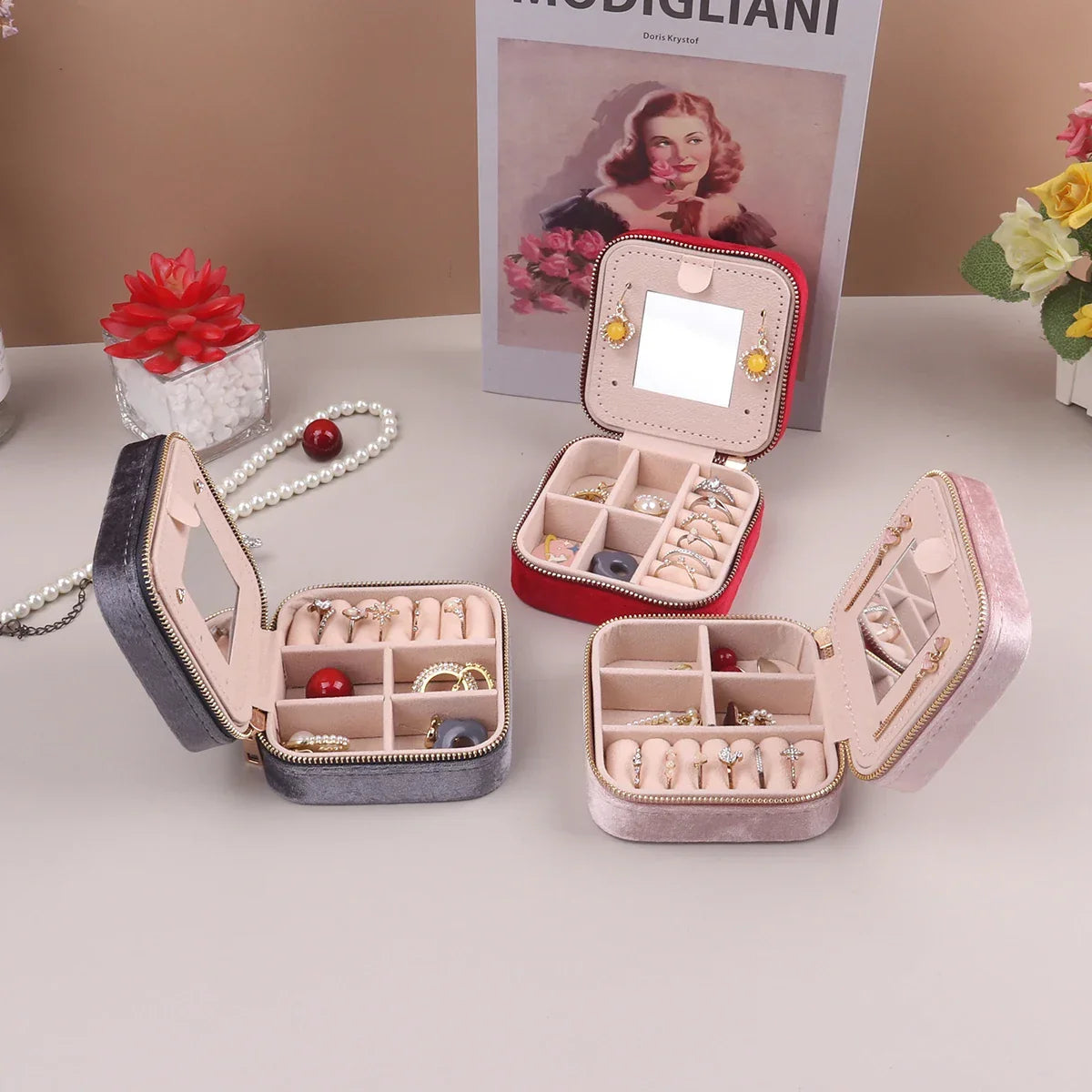 Open view of women's velvet travel jewelry organizer, showcasing compartments for rings, necklaces, earrings.