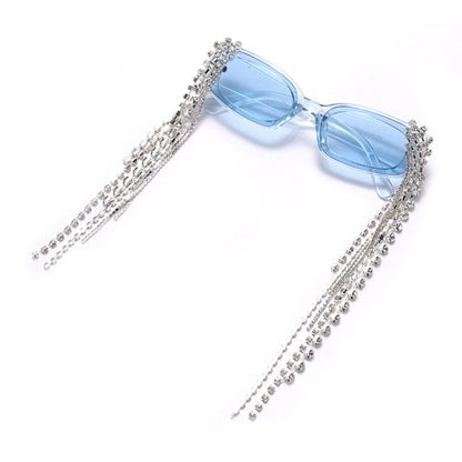 Close-up of women's rhinestone sunglasses, intricate tassel detail & gradient lens finish.