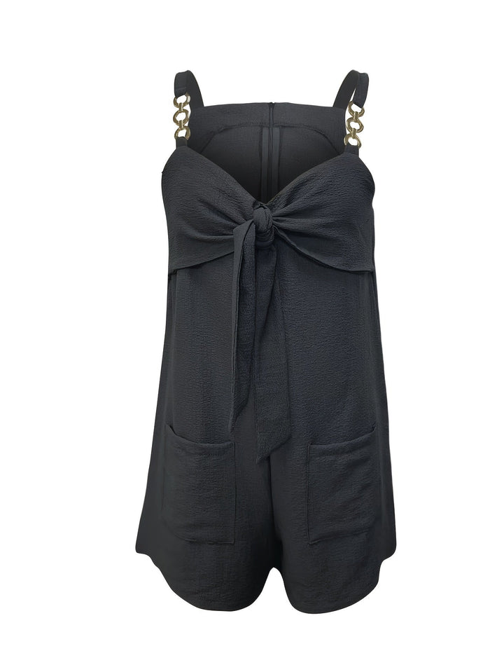 Detailed view of the chain straps on a green textured short romper with sweetheart bow.