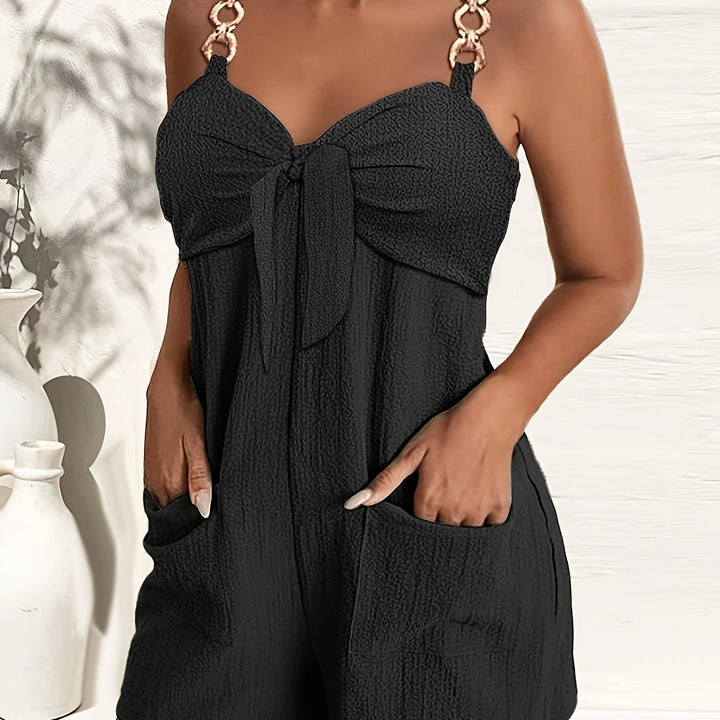 Black textured women's romper, showcasing the sweetheart bow & chic chain strap detail.