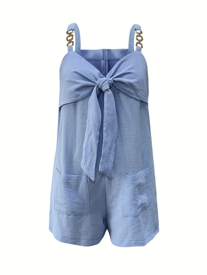 Women's textured black romper with prominent sweetheart bow and stylish chain straps.